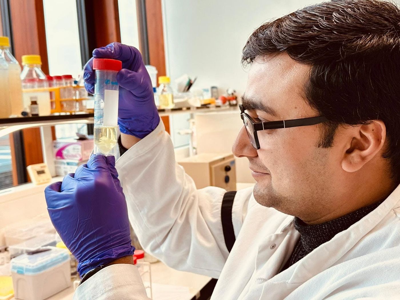 Kailash inspecting a sample tube at the lab bench