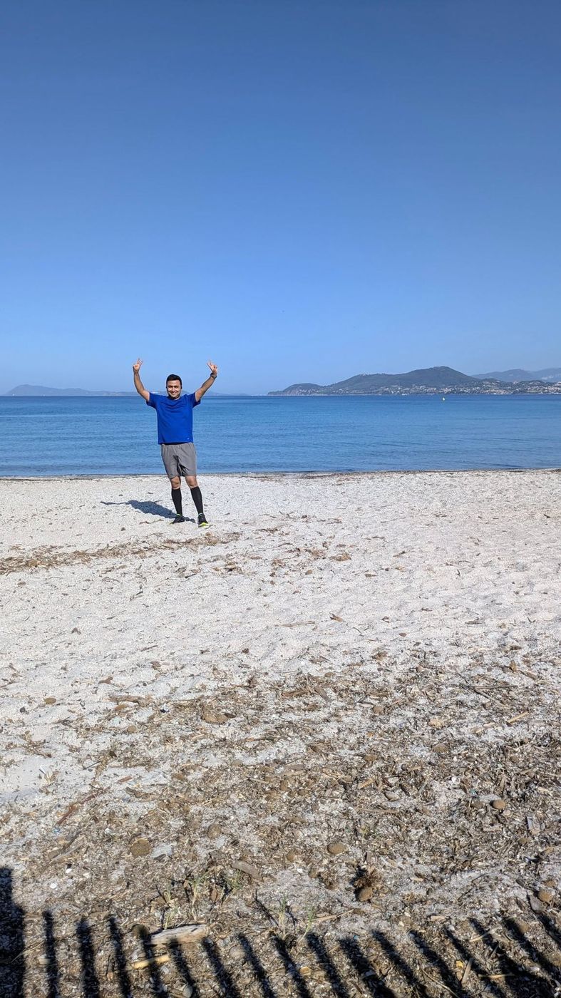Victory pose after a beach run by the sea